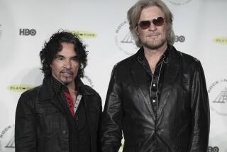 FILE - Hall of Fame Inductees, Hall & Oates, John Oates and Daryl Hall appear in the press room at the 2014 Rock and Roll Hall of Fame Induction Ceremony on April, 10, 2014, in New York. Hall has sued his longtime music partner John Oates, arguing that his plan to sell off his share of a joint venture would violate a business agreement the duo had. (Photo by Andy Kropa/Invision/AP, File)