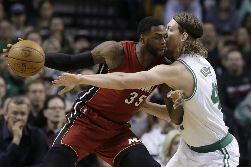 Then-Miami Heat forward Willie Reed, left, tries to drive past Boston Celtics center Kelly Olynyk on March 26 in Boston.