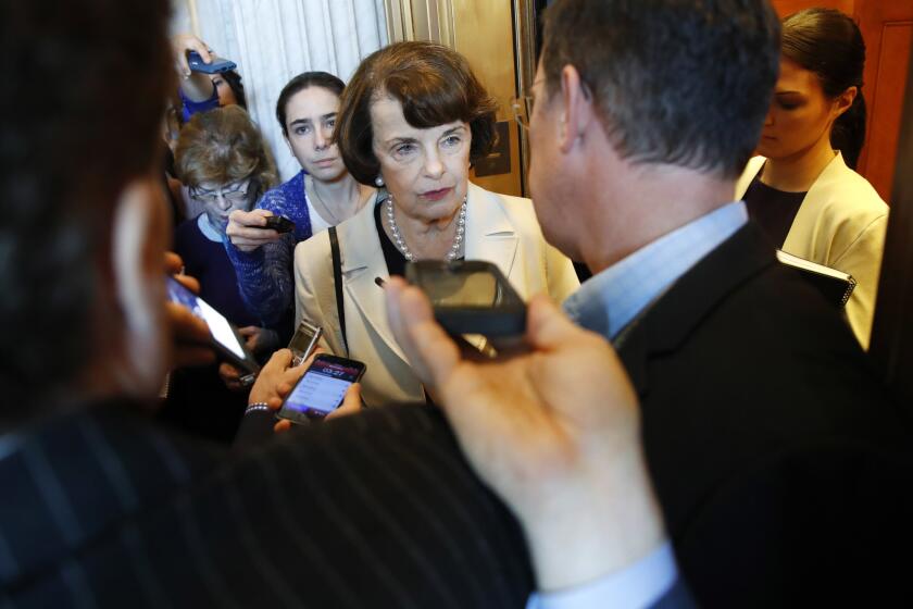 Sen. Dianne Feinstein surrounded by people with microphones and recorders