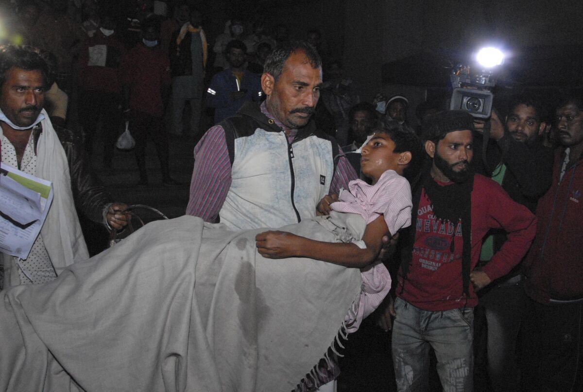 A man carries a child out from the Kamla Nehru Children’s Hospital after a fire in the newborn care unit of the hospital killed four infants, in Bhopal, India, Monday, Nov. 8, 2021. There were 40 children in total in the unit, out of which 36 have been rescued, said Medical Education Minister Vishwas Sarang. (AP Photo)