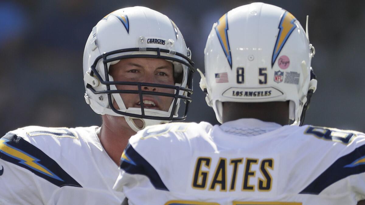 Chargers quarterback Philip Rivers talks with tight end Antonio Gates during a break in the action.