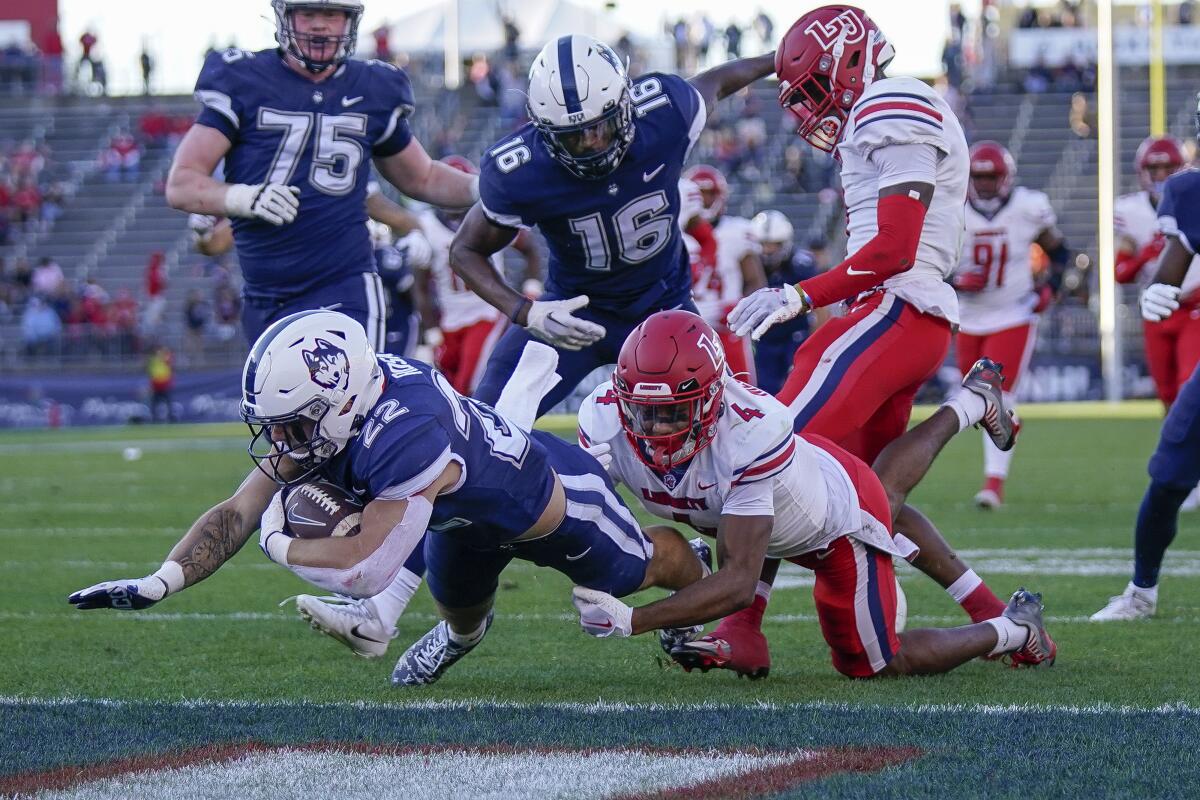 Connecticut running back Victor Rosa (22) scores a touchdown during the second half of an NCAA college football game against against Liberty in East Hartford, Conn., Saturday, Nov. 12, 2022. (AP Photo/Bryan Woolston)