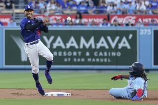 Los Angeles Dodgers second baseman Mookie Betts, left, completes a double play over Toronto Blue Jays' Vladimir Guerrero Jr. on a ground ball from Matt Chapman during the first inning of a baseball game Tuesday, July 25, 2023, in Los Angeles. (AP Photo/Marcio Jose Sanchez)