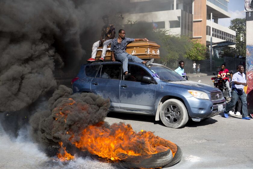 Un automóvil lleva el lunes 4 de marzo de 2019 un ataúd con el cuerpo de un manifestante que murió durante unas protestas en Puerto Príncipe, Haití. (AP Foto/Dieu Nalio Chery)
