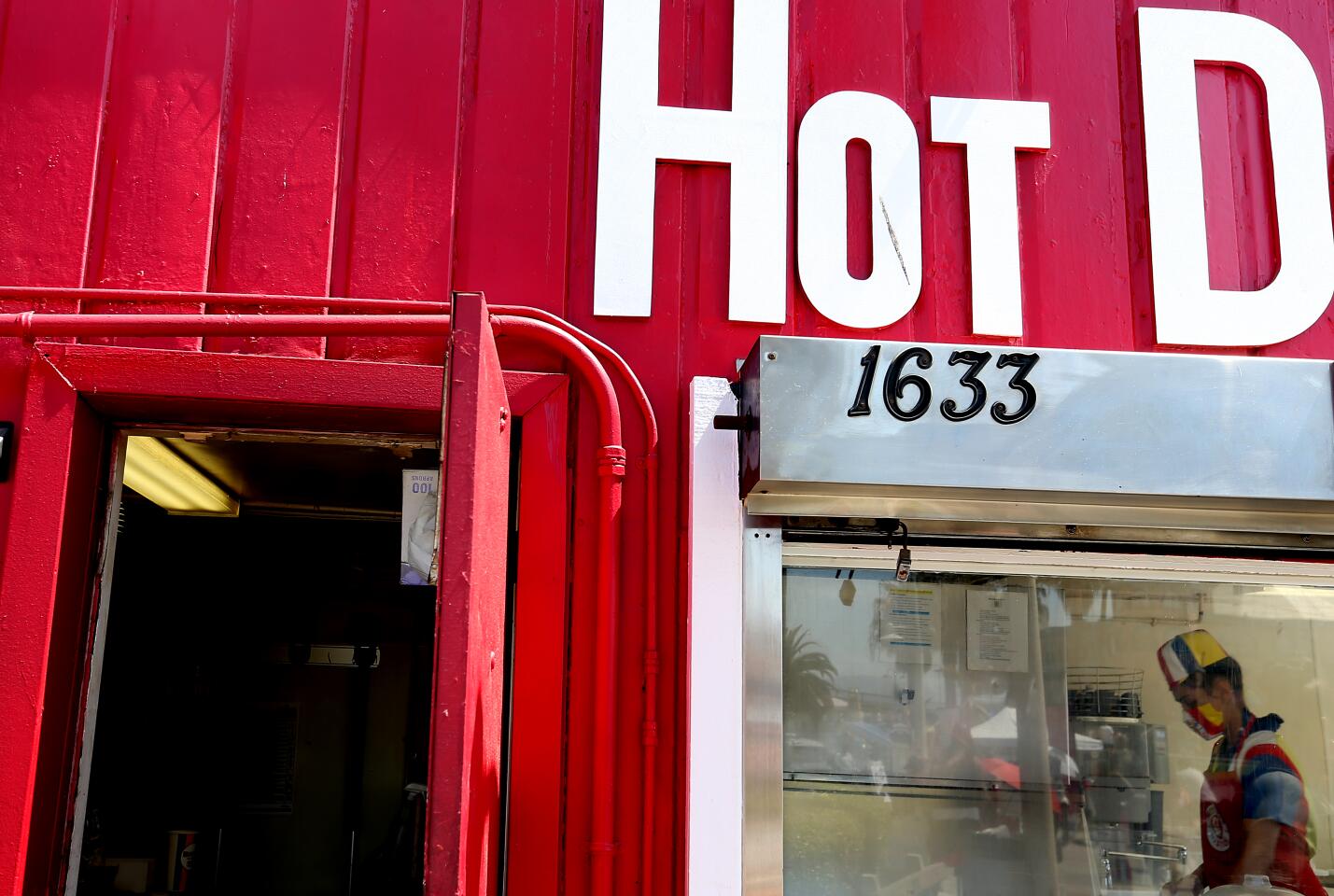 An employee of a hot dog stand works inside the eatery in Santa Monica.