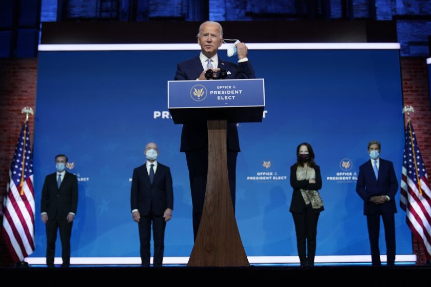 President-elect Joe Biden removes his face mask as he arrives to introduce his nominees and appointees to key national security and foreign policy posts at The Queen theater, Tuesday, Nov. 24, 2020, in Wilmington, Del. (AP Photo/Carolyn Kaster)