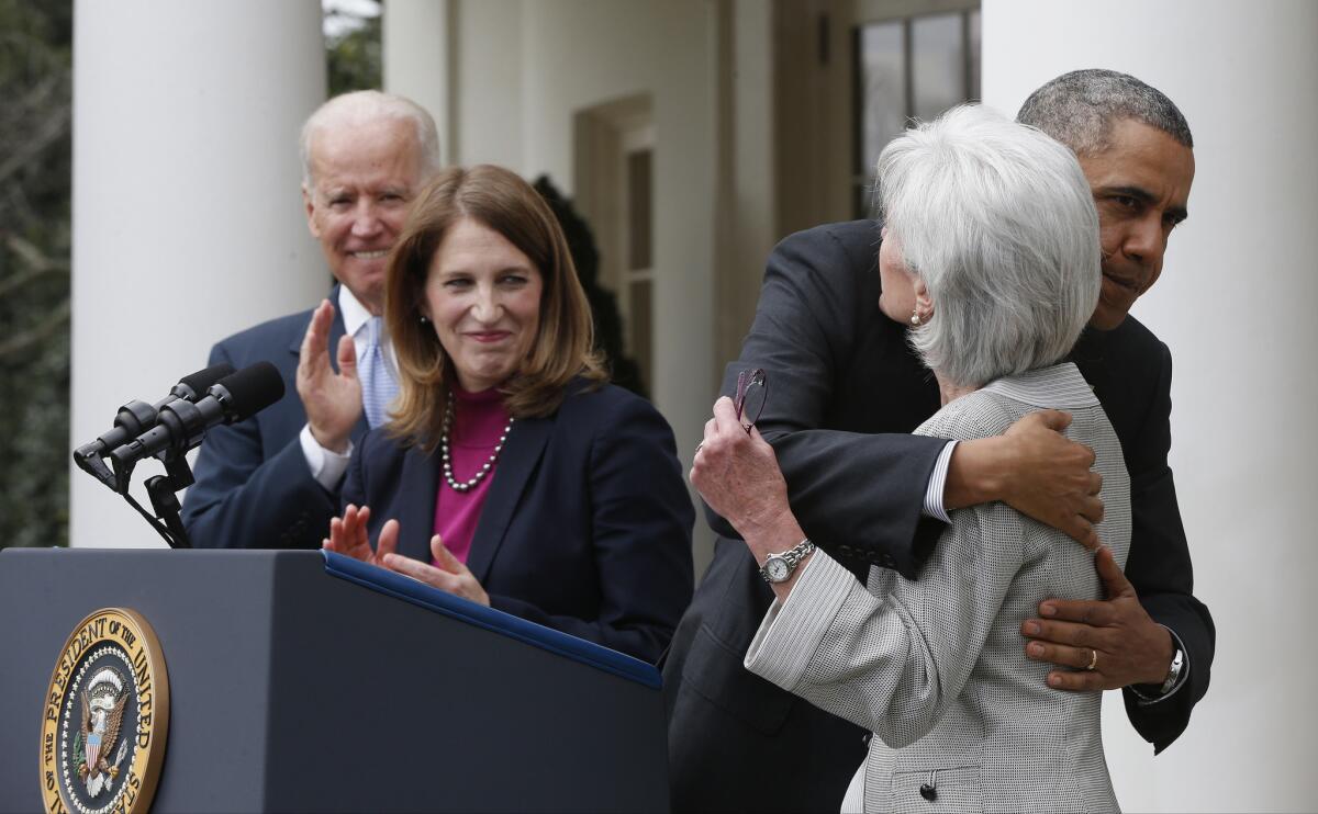 President Obama hugs outgoing Health and Human Services Secretary Kathleen Sebelius as he stands with Vice President Joe Biden and Sylvia Mathews Burwell, his nominee to replace her.