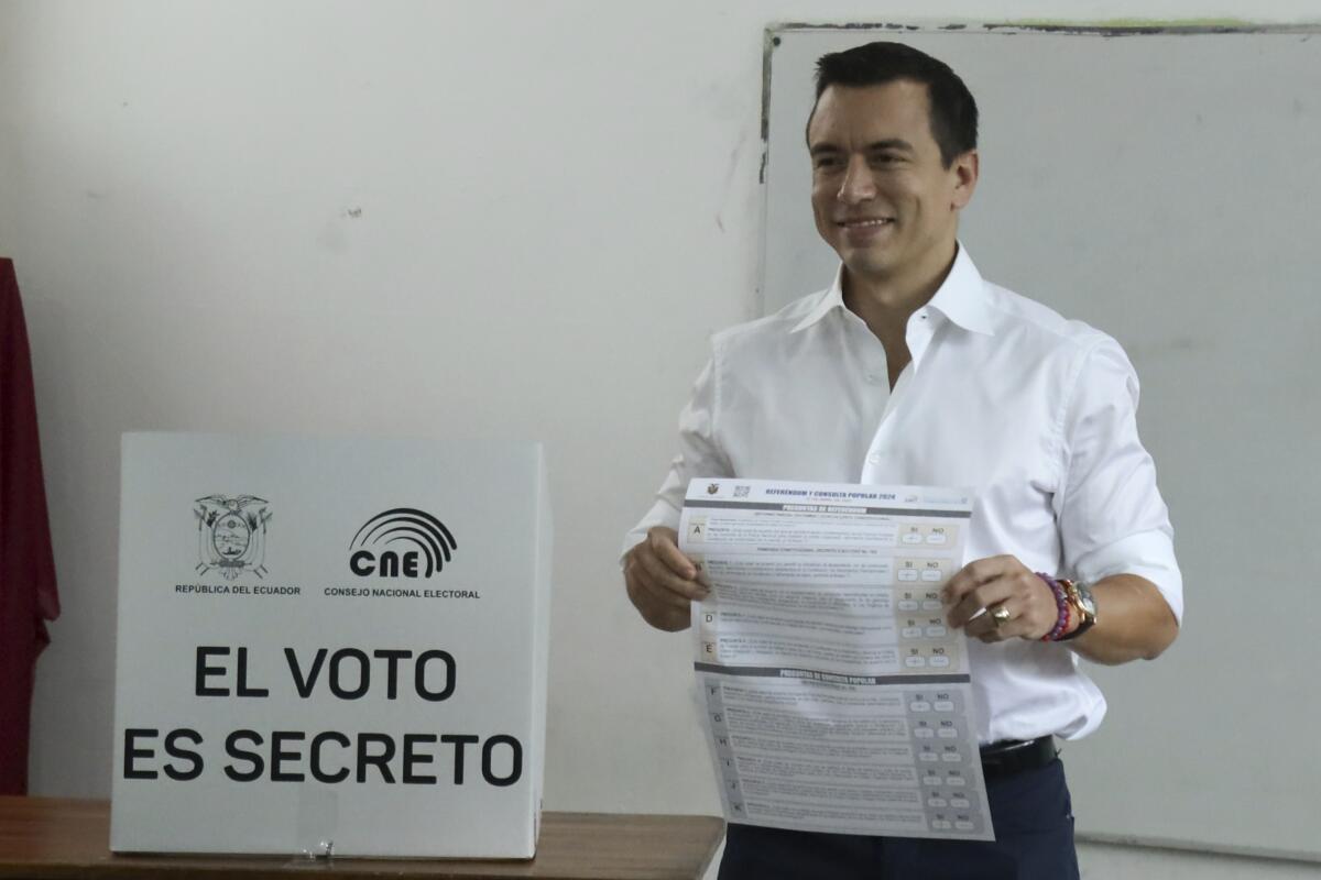 President Daniel Noboa holds the ballot during a referendum to endorse new security measures to crackdown on criminal gangs responsible for increasing violence in Olon, Ecuador, Sunday, April 21, 2024. (AP Photo/Cesar Munoz)