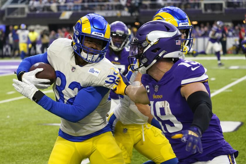 Los Angeles Rams linebacker Travin Howard (32) runs from Minnesota Vikings wide receiver Adam Thielen (19) after intercepting a pass during the first half of an NFL football game, Sunday, Dec. 26, 2021, in Minneapolis. (AP Photo/Jim Mone)