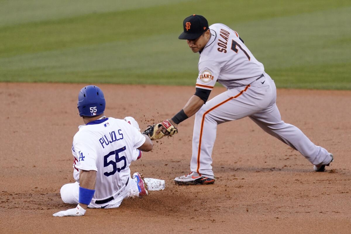 Albert Pujols slides under the tag of San Francisco Giants shortstop Donovan Solano.
