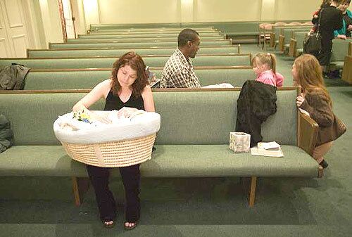 LETTING GO: Danielle Hayworth sits with her son after his funeral in Wichita. Lee lay in a Moses basket with a stuffed bunny at his feet. Wrapped in a white satin blanket embroidered with angel wings, he wore a bib that said Daddys Boy.