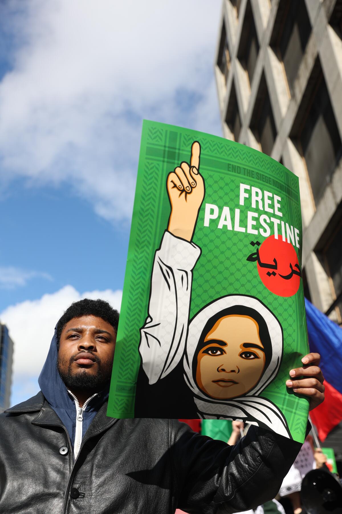 A man holds a 'Free Palestine' sign while 