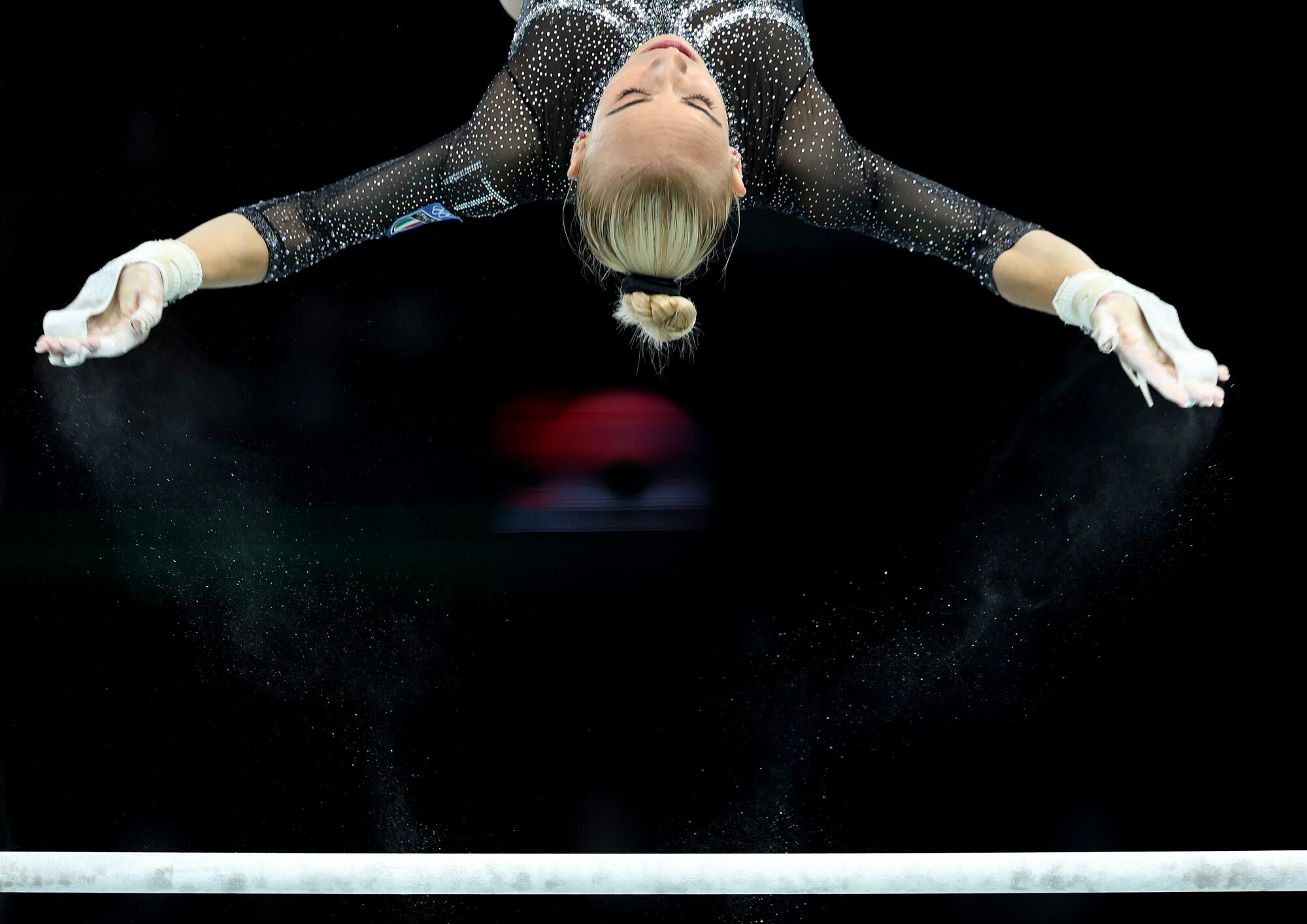 Italy's Alice D'Amato competes on the uneven bars during qualifying for women's team gymnastics.