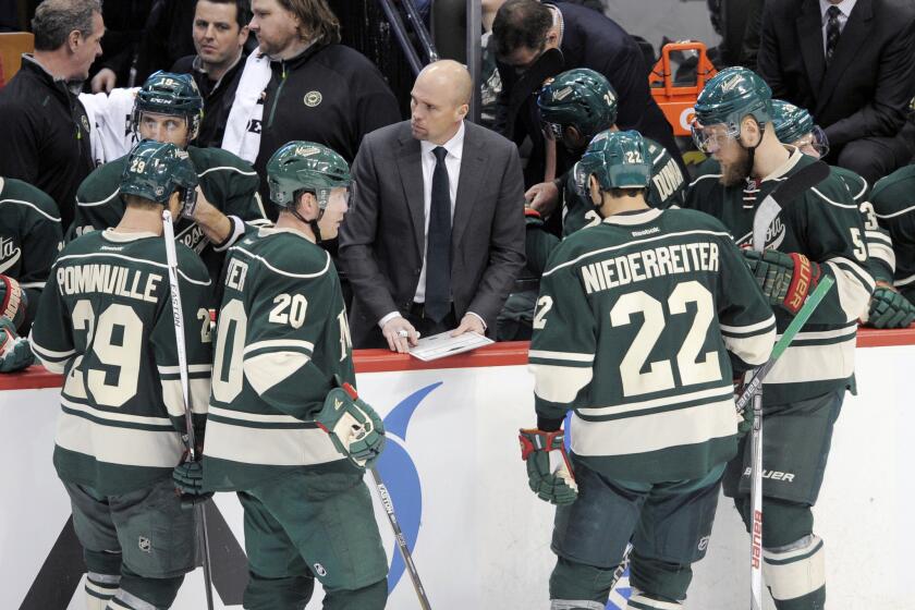 Minnesota Wild Coach Mike Yeo, center, diagrams a play for his team during the third period of a game against the Dallas Stars on Feb. 9.