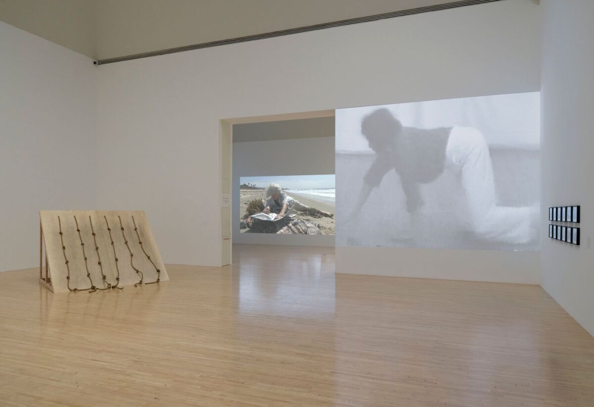 art installation with sculpture, left, and video screen