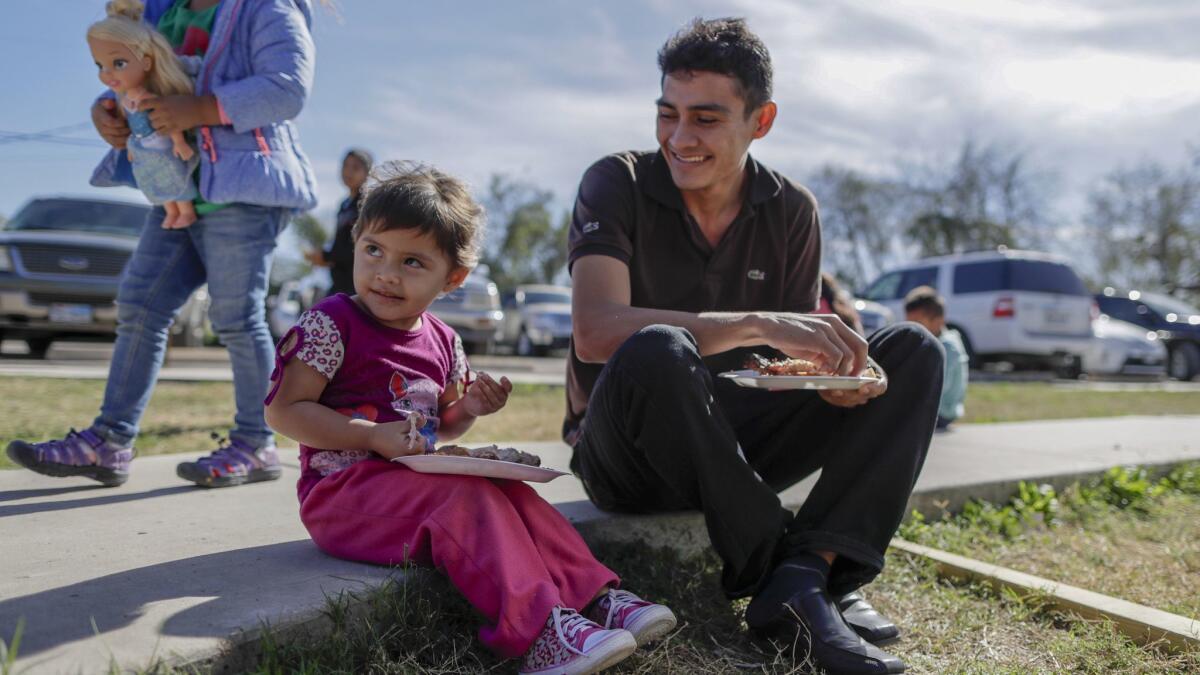Juan Pablo Lazo with his daughter Marjorie, 2, at the Catholic Charities Respite Center. Lazo, who is from El Salvador, said he was robbed while traveling through Monterrey, Mexico.