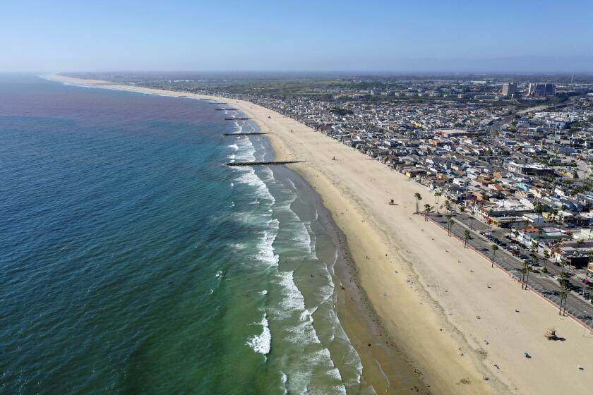 NEWPORT BEACH, CA -- MONDAY, MAY 4, 2020: An aerial view of a small amount of surfers and beach-goers enjoying a nice day at the beach despite Gov. Gavin Newsom's hard closure, which is still in place in Newport Beach, CA, on May 4, 2020. (Allen J. Schaben / Los Angeles Times)