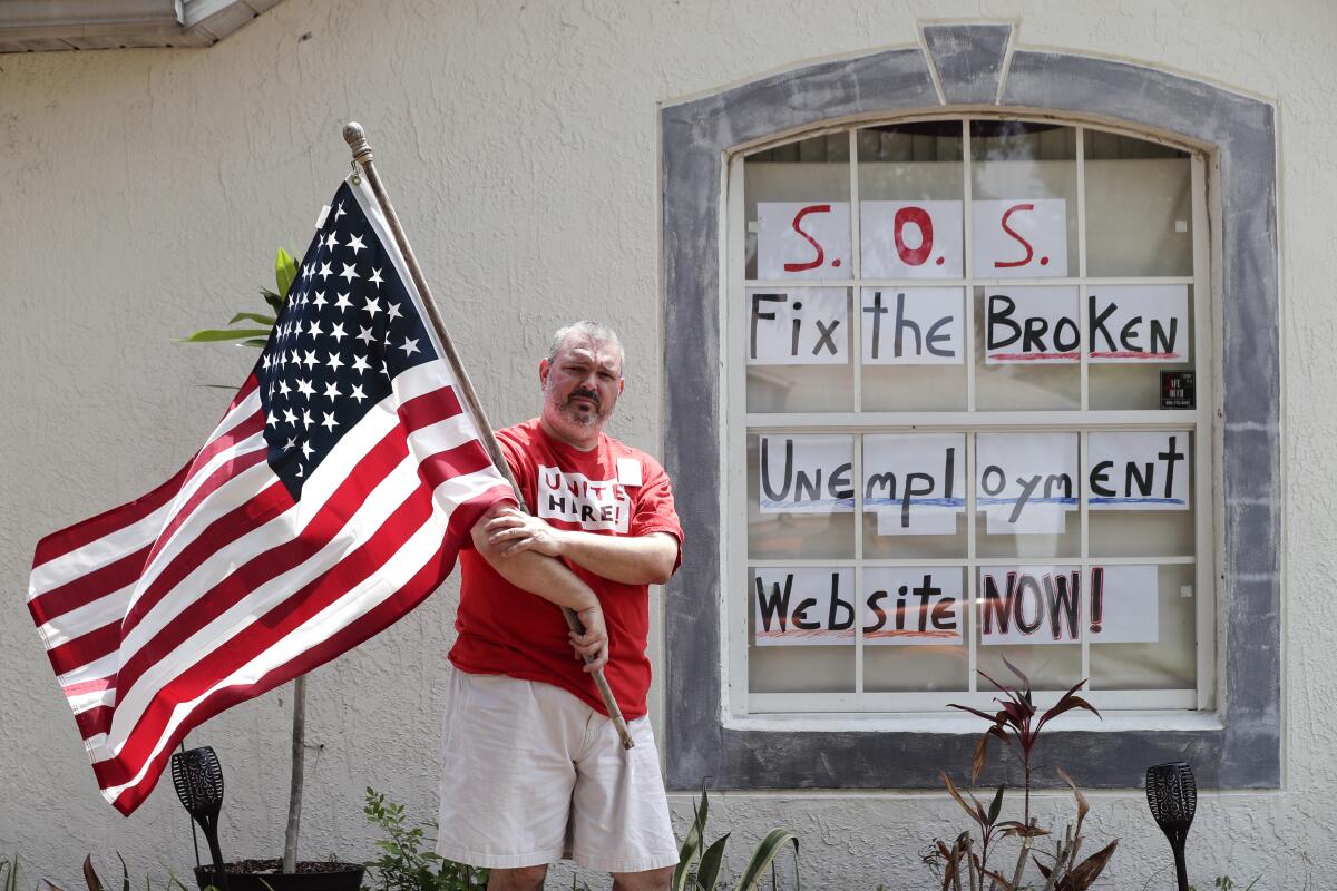 Hew Kowalewski, a furloughed employee of Disney World, stands next to a window of his home in Kissimmee, Fla., on April 13.