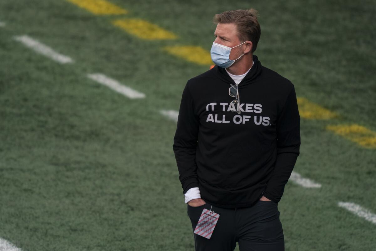 Rams general manager Les Snead stands on the field before a playoff game against the Seattle Seahawks in January.