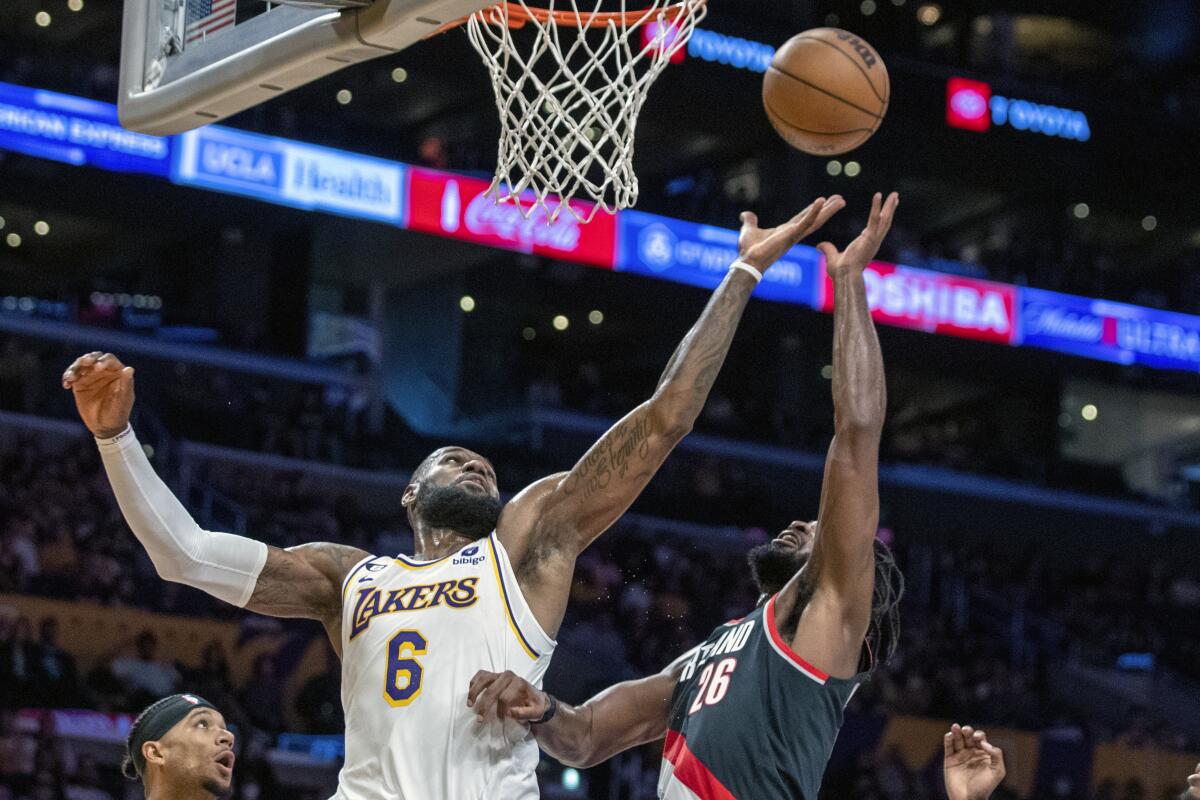 Lakers forward LeBron James, left, battles Portland Trail Blazers forward Justise Winslow.
