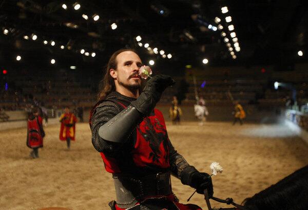 The Red Knight, a.k.a. William Elliot III, prepares to throw a flower into the audience during a show at Medieval Times. Once an aspiring magician in Las Vegas, he's now the assistant head knight at the Buena Park site.