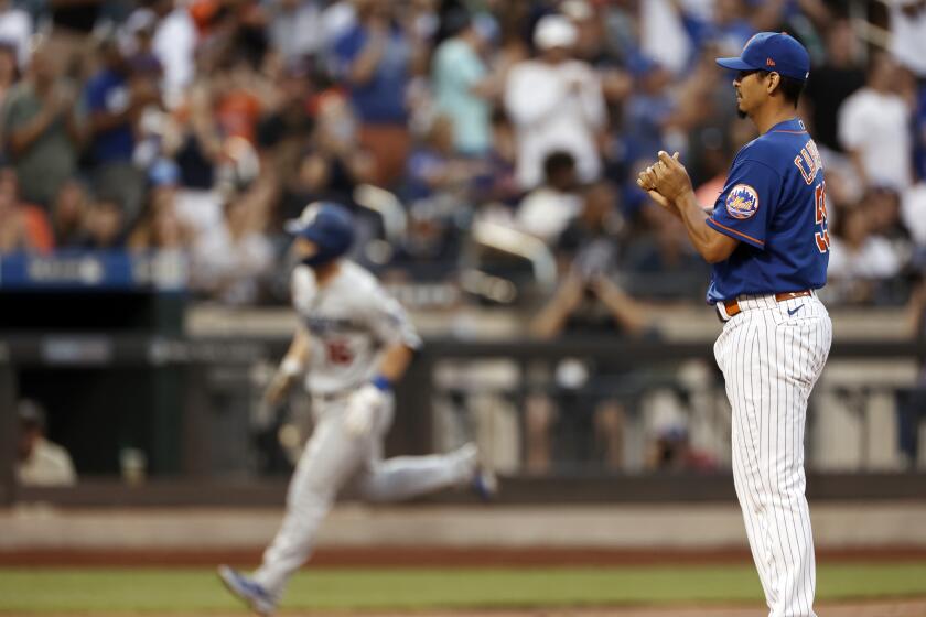 New York Mets pitcher Carlos Carrasco reacts during the first inning of a baseball game after giving up a home run to Los Angeles Dodgers' Will Smith on Sunday, Aug. 15, 2021, in New York. (AP Photo/Adam Hunger)