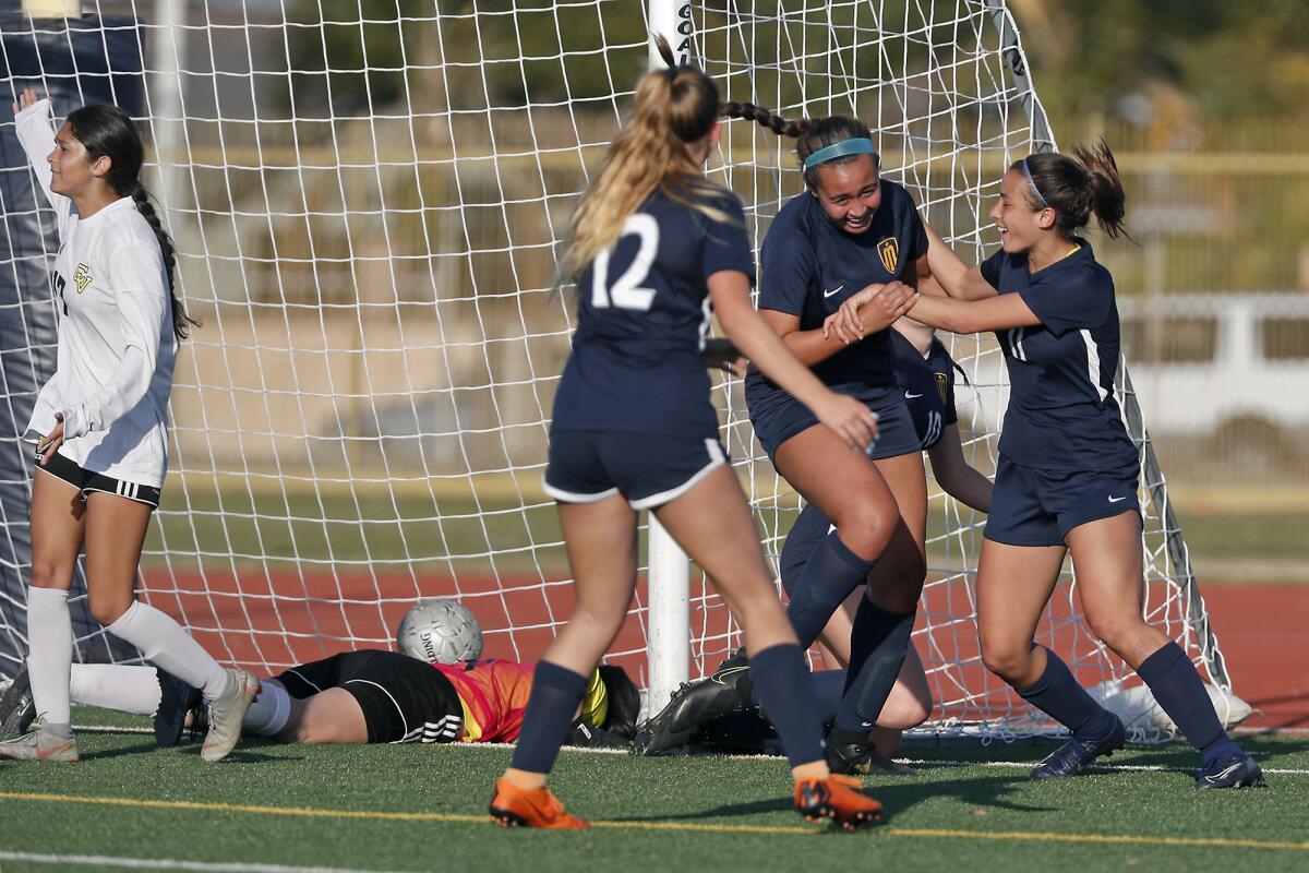 Marina's McKenna Pua, second from right, is congratulated by teammate Renee Mangold, right, and Alexis VanHorn after scoring a goal against Capistrano Valley in the 61st minute of the CIF Southern Section Division 2 quarterfinal playoff match on Wednesday.