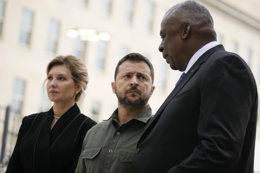 FILE - Secretary of Defense Lloyd Austin, speaks with Ukrainian President Volodymyr Zelenskyy during a wreath laying ceremony at the 9/11 Pentagon Memorial, Sept. 21, 2023, in Washington, as first lady of Ukraine, Olena Zelenska, looks on. The Pentagon is warning Congress that it is running low on funding to replace weapons the U.S. has sent to Ukraine and has already been forced to slow down restocking some troops. The warning from the Pentagon comptroller came in a letter sent to congressional leaders and was obtained by The Associated Press. (AP Photo/Andrew Harnik, File)