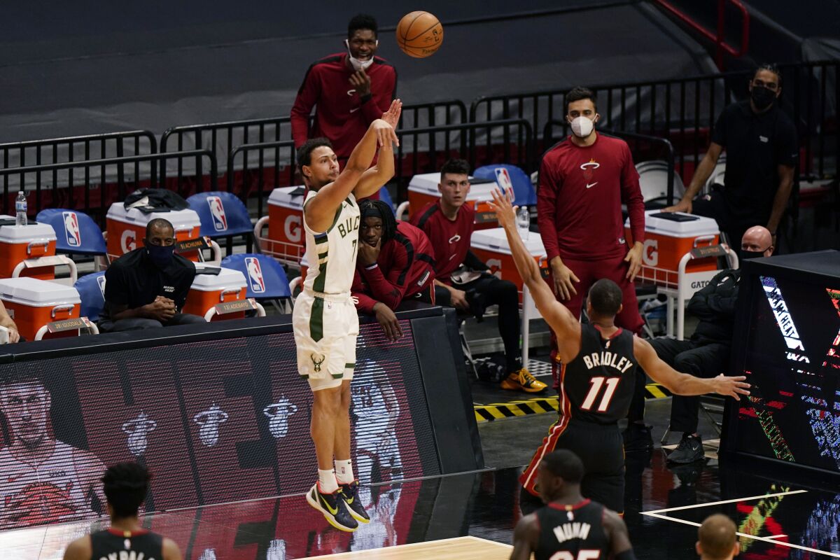 Milwaukee Bucks guard Bryn Forbes attempts a 3-point basket as Miami Heat guard Avery Bradley defends.