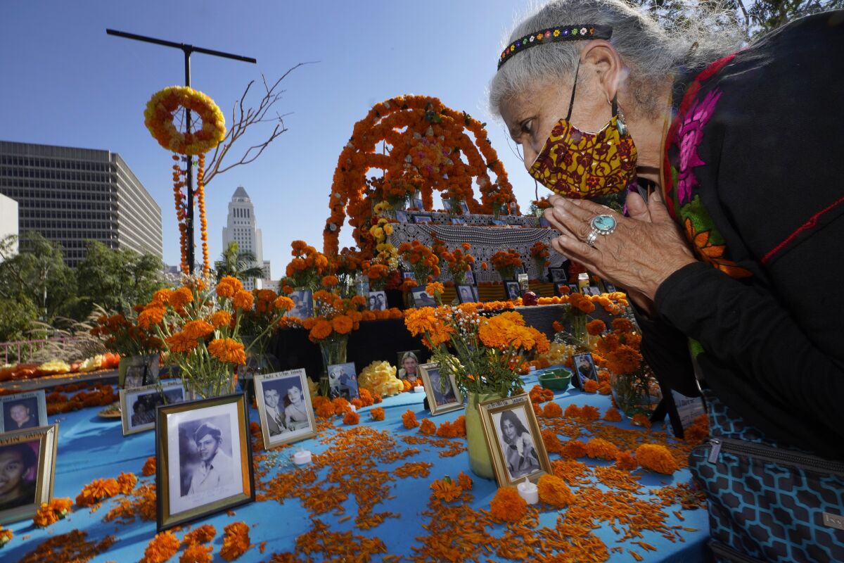 Ofelia Esparza, 88, has brough fresh marigolds and placed them next to pictures of family members who died.