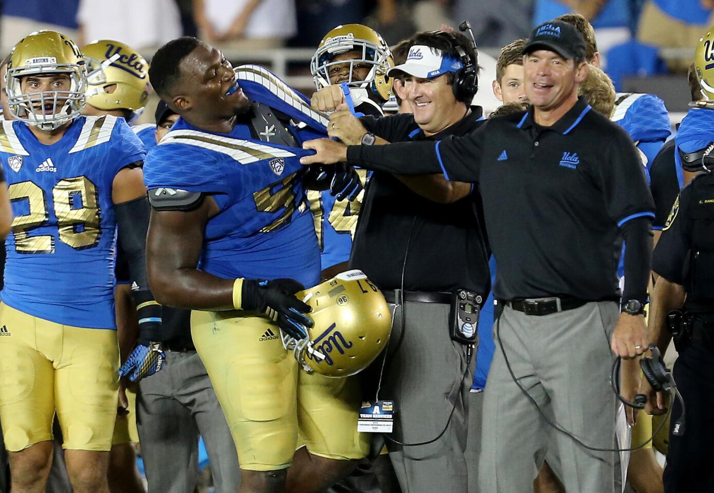 UCLA Coach Jim Mora, right, shares a light moment with defensive lineman Kenny Clark after the Bruins' 24-23 victory over BYU earlier this season.