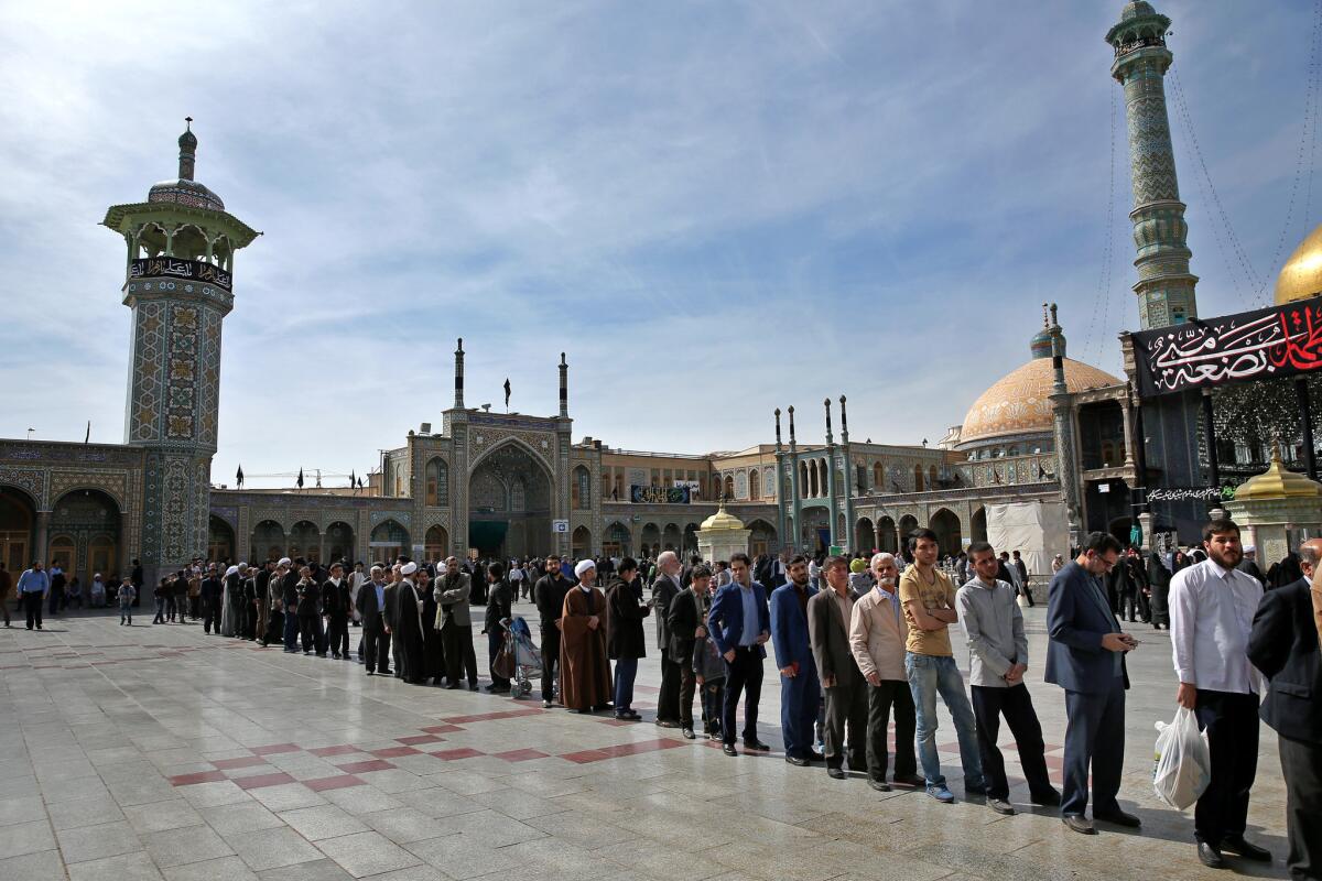 Iranians stand in line outside a polling station during the parliamentary and Experts Assembly elections in Qom on Friday.