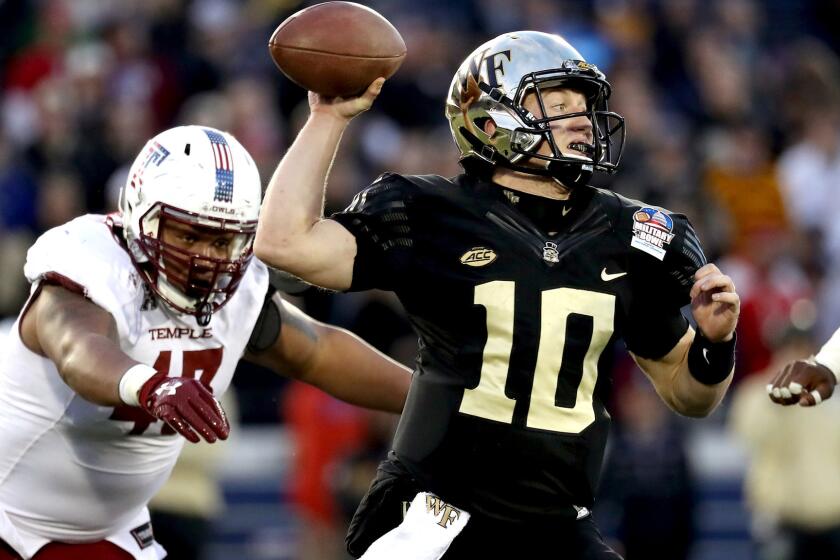 Wake Forest quarterback John Wolford attempts a pass while under pressure from Temple defensive lineman Averee Robinson during the second quarter Tuesday.