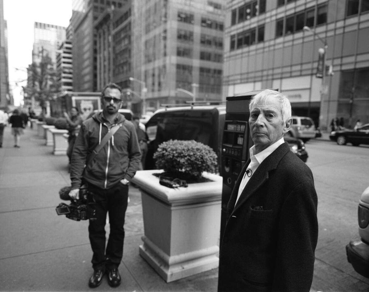 Andrew Jarecki, left, and Robert Durst stand on a street near a planter.