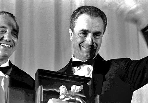 The director waves at the Venice Film Festival in 1964.