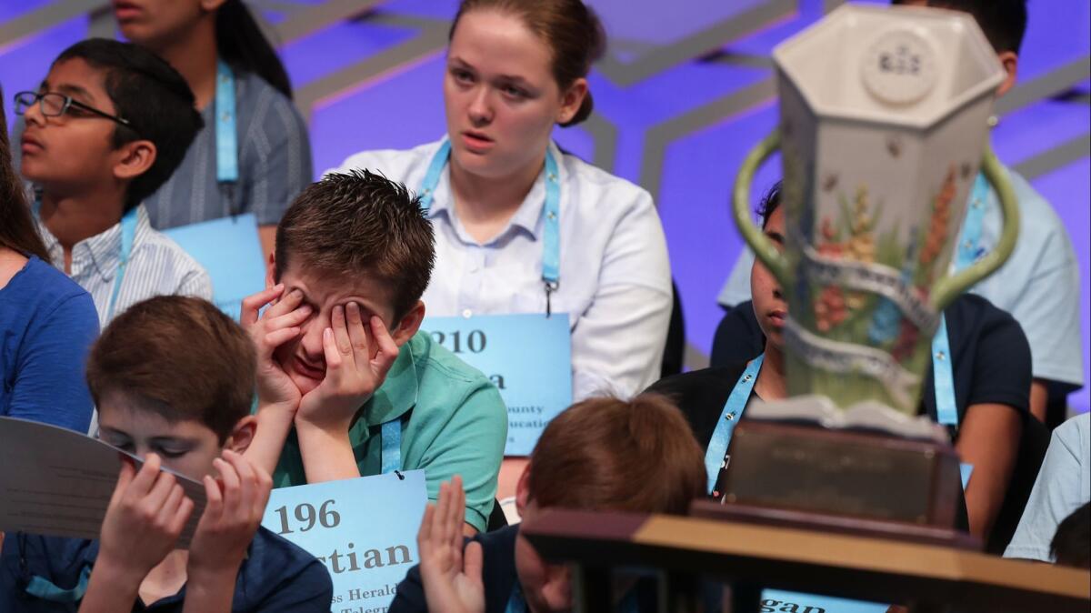 Students await their turns Tuesday during the second round of the Scripps National Spelling Bee in the shadow of the trophy at the Gaylord National Resort and Convention Center in National Harbor, Md.