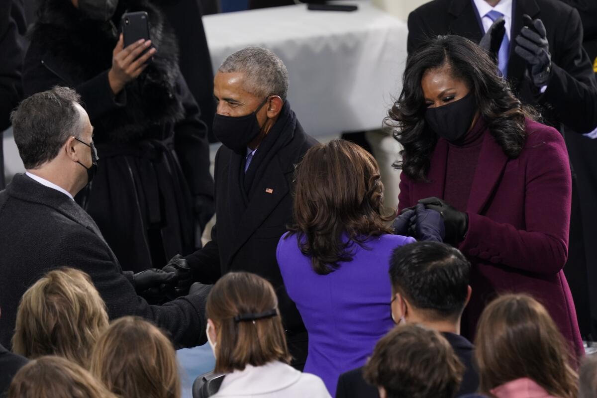 Kamala Harris, dressed in blue, along with Doug Emhoff talk with Barack Obama and Michelle Obama