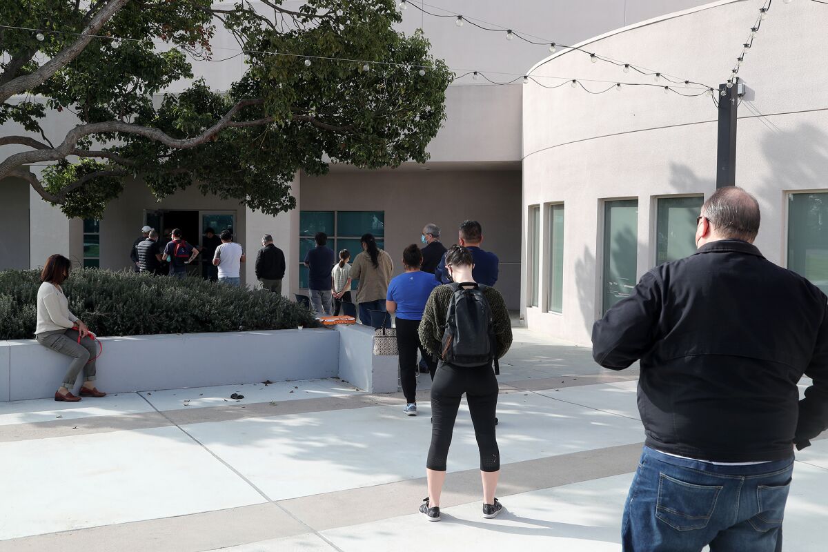 Patients wait in line at a vaccine clinic on Friday at the Costa Mesa Senior Center.