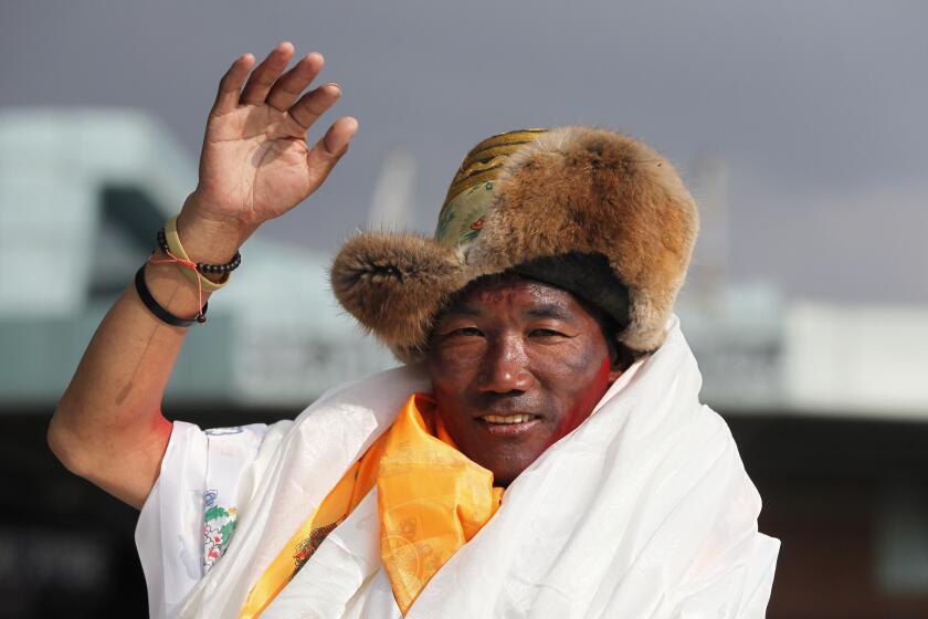 FILE - In this May 20, 2018, file photo, Nepalese veteran Sherpa guide, Kami Rita waves as he arrives in Kathmandu, Nepal. Rita, one of the greatest mountain guides regained his title with the most climbs of Mount Everest after scaling the peak for the 27th time on Wednesday, just three days after a fellow Sherpa climber had equalled his previous record. (AP Photo/Niranjan Shrestha, File)