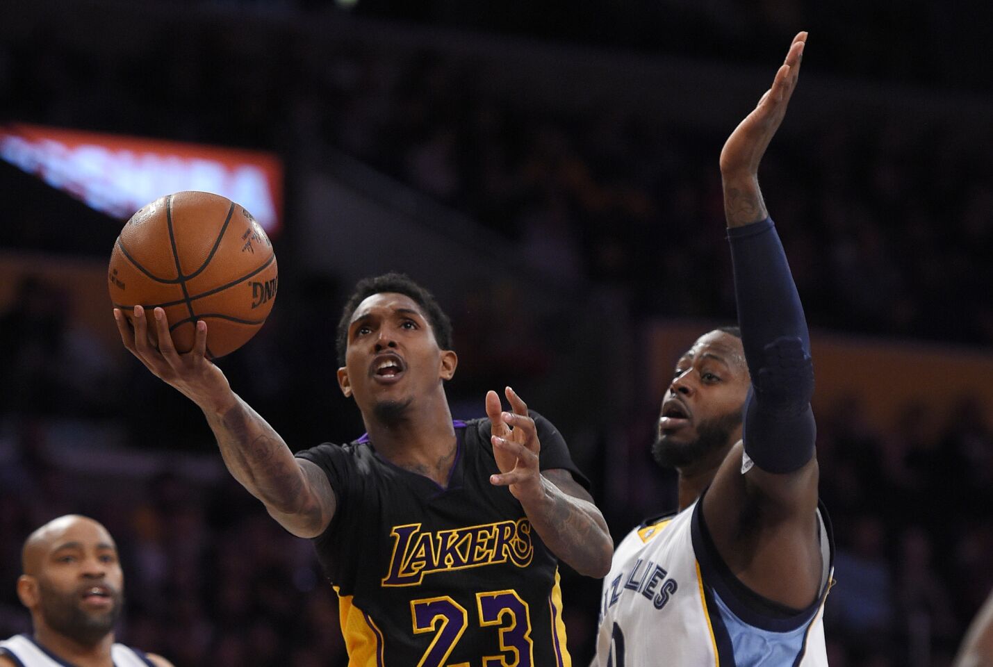 Lakers guard Lou Williams, left, shoots as Grizzlies forward JaMychal Green defends during the first half of a game on Feb. 26 at Staples Center.