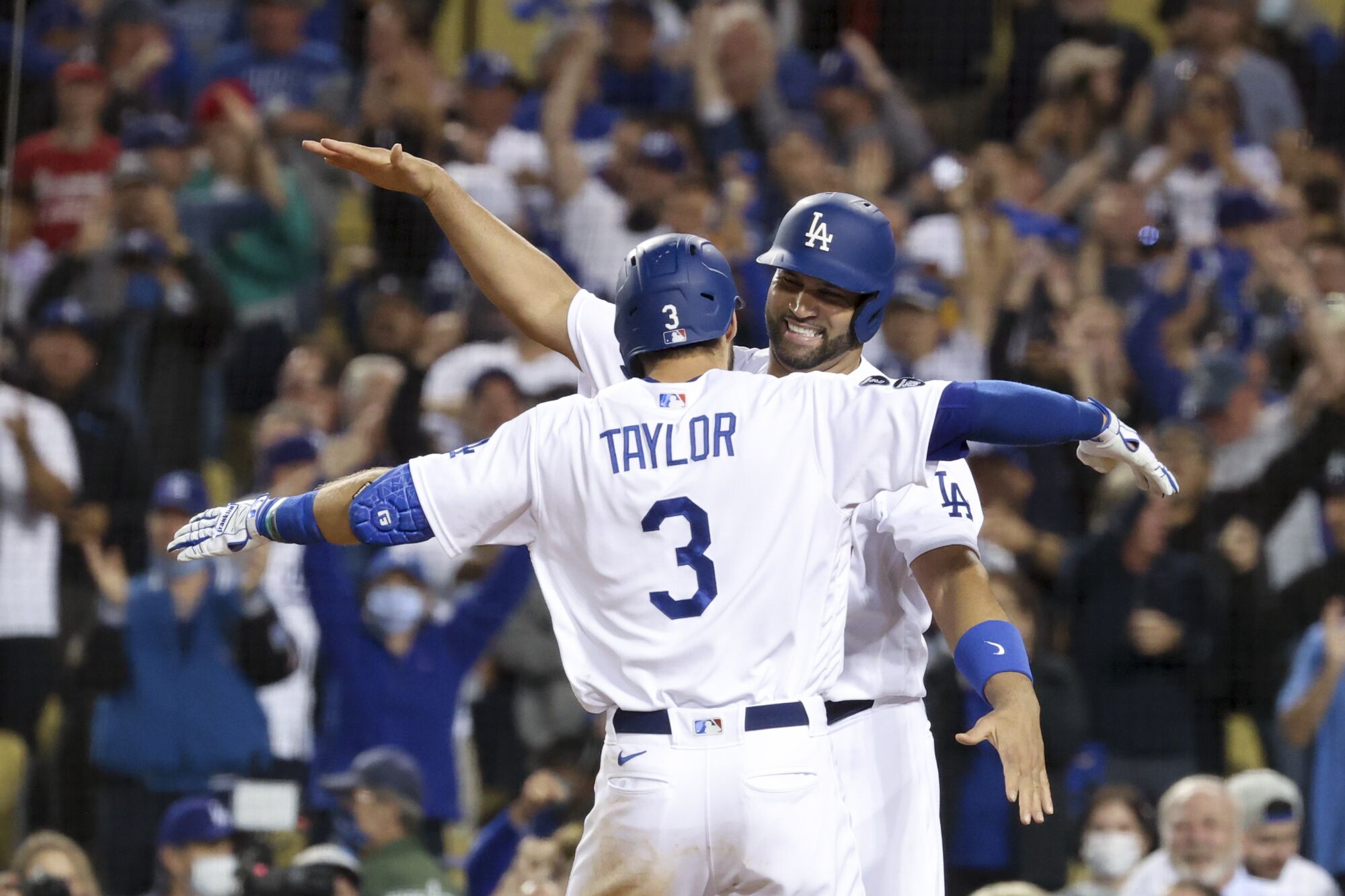 Dodgers' Chris Taylor hugs Albert Pujols.