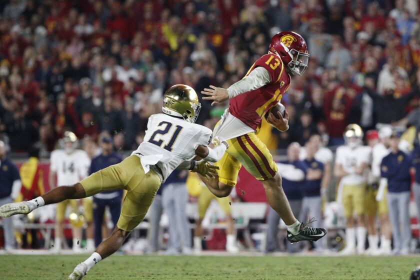 USC quarterback Caleb Williams evades a tackle attempt by Notre Dame cornerback Jaden Mickey 