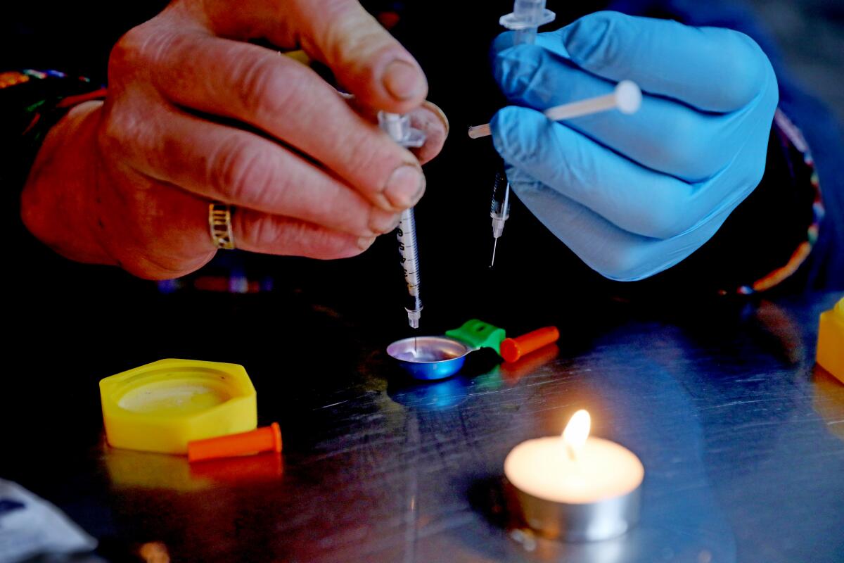 A fentanyl addict prepares an injection of fentanyl to be given to himself.