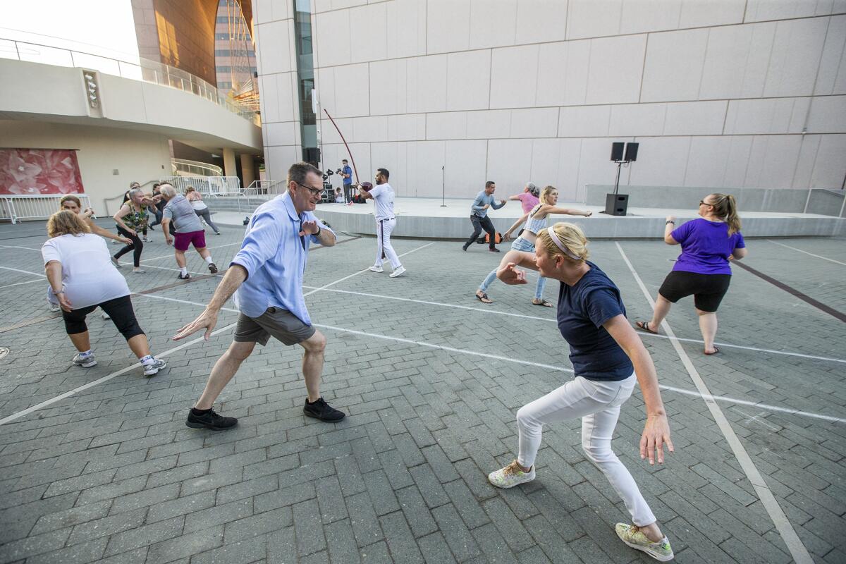 Mark and Dina Waters practice capoeira at Segerstrom Center's Argyros Plaza on Tuesday.