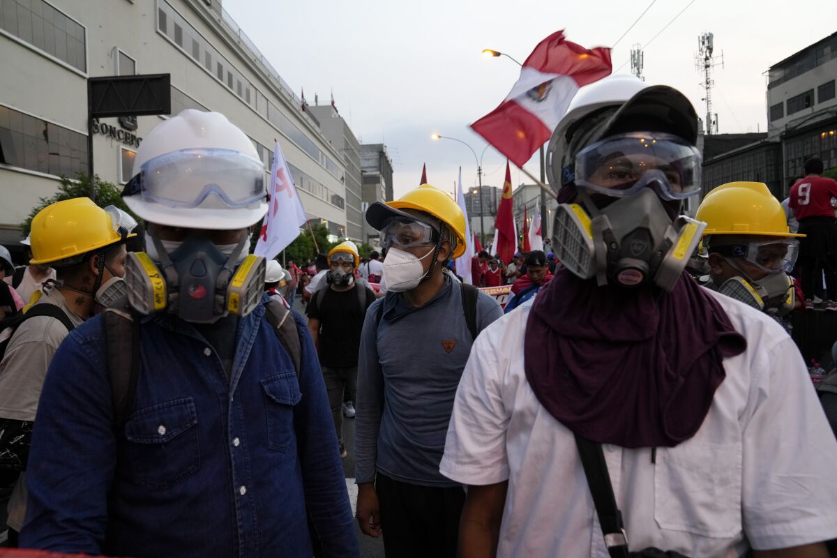 Manifestantes antigubernamentales usan cascos y máscaras antigás en Lima, Perú, el martes 31 de enero de 2023. Perú enfrenta una crisis política con prolongadas protestas que exigen la dimisión de la presidenta Dina Boluarte y los miembros del Congreso. (Foto AP/Martín Mejía)
