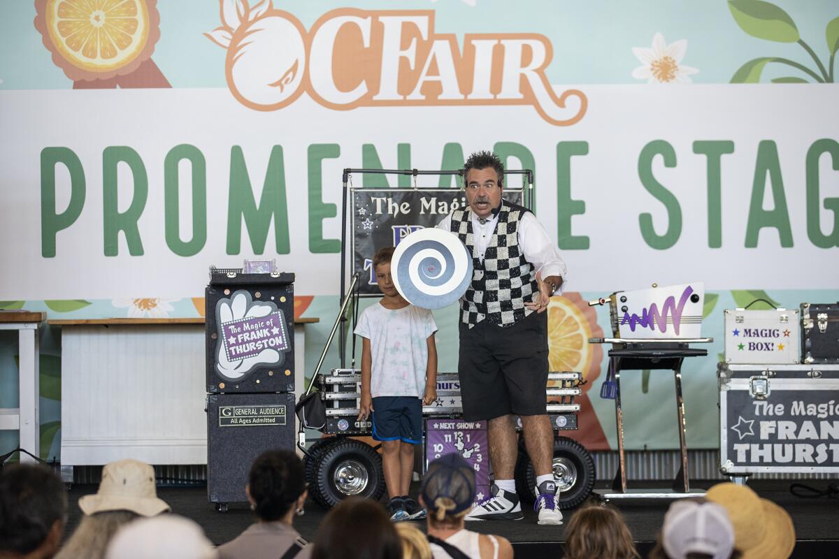 Frank Thurston performs a trick with Rocky, 6, during an afternoon show on Thursday at the O.C. Fair.