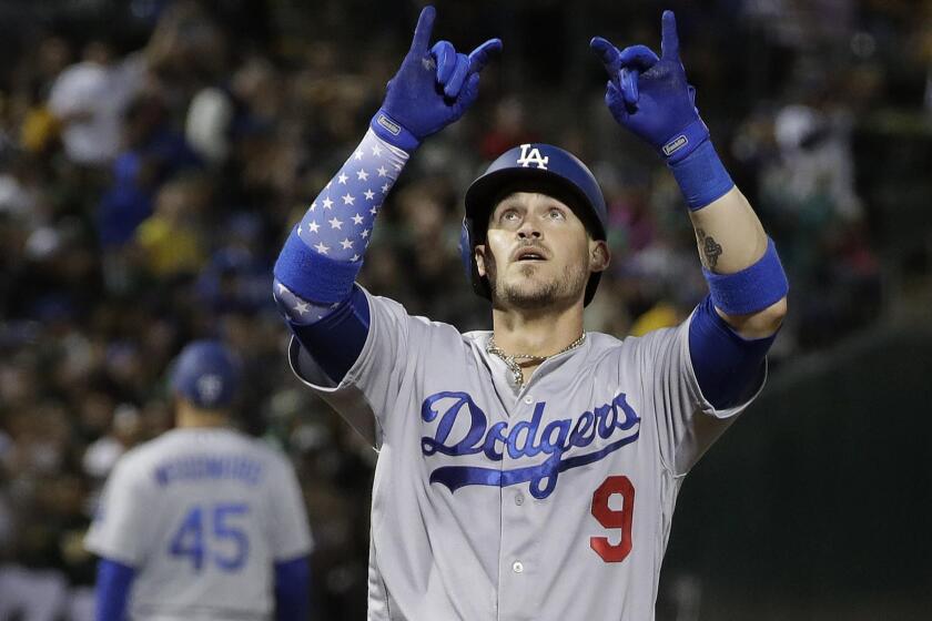 Los Angeles Dodgers' Yasmani Grandal (9) celebrates after hitting a home run against the Oakland Athletics during the fifth inning of a baseball game in Oakland, Calif., Wednesday, Aug. 8, 2018. (AP Photo/Jeff Chiu)