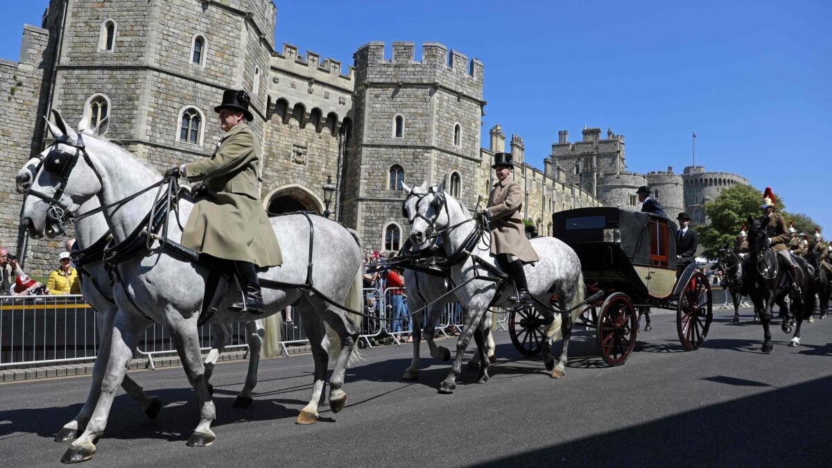 Windsor Grey horses pull the Ascot Landau carriage past the Henry VIII gate during a rehearsal for the wedding procession outside Windsor Castle on May 17, 2018.