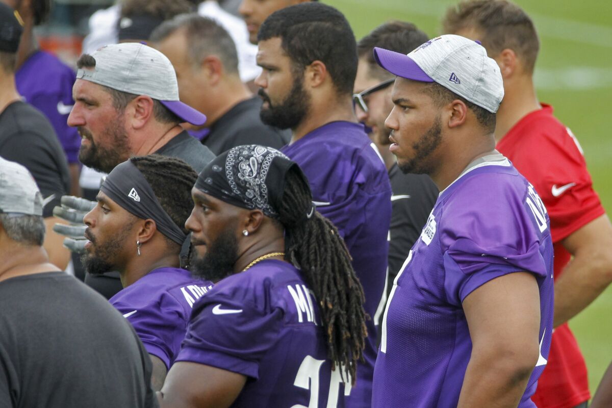 Minnesota Vikings linemen Christian Darrisaw, right, front, watches drills during NFL football training camp Wednesday, July 28, 2021, in Eagan, Minn. (AP Photo/Bruce Kluckhohn)