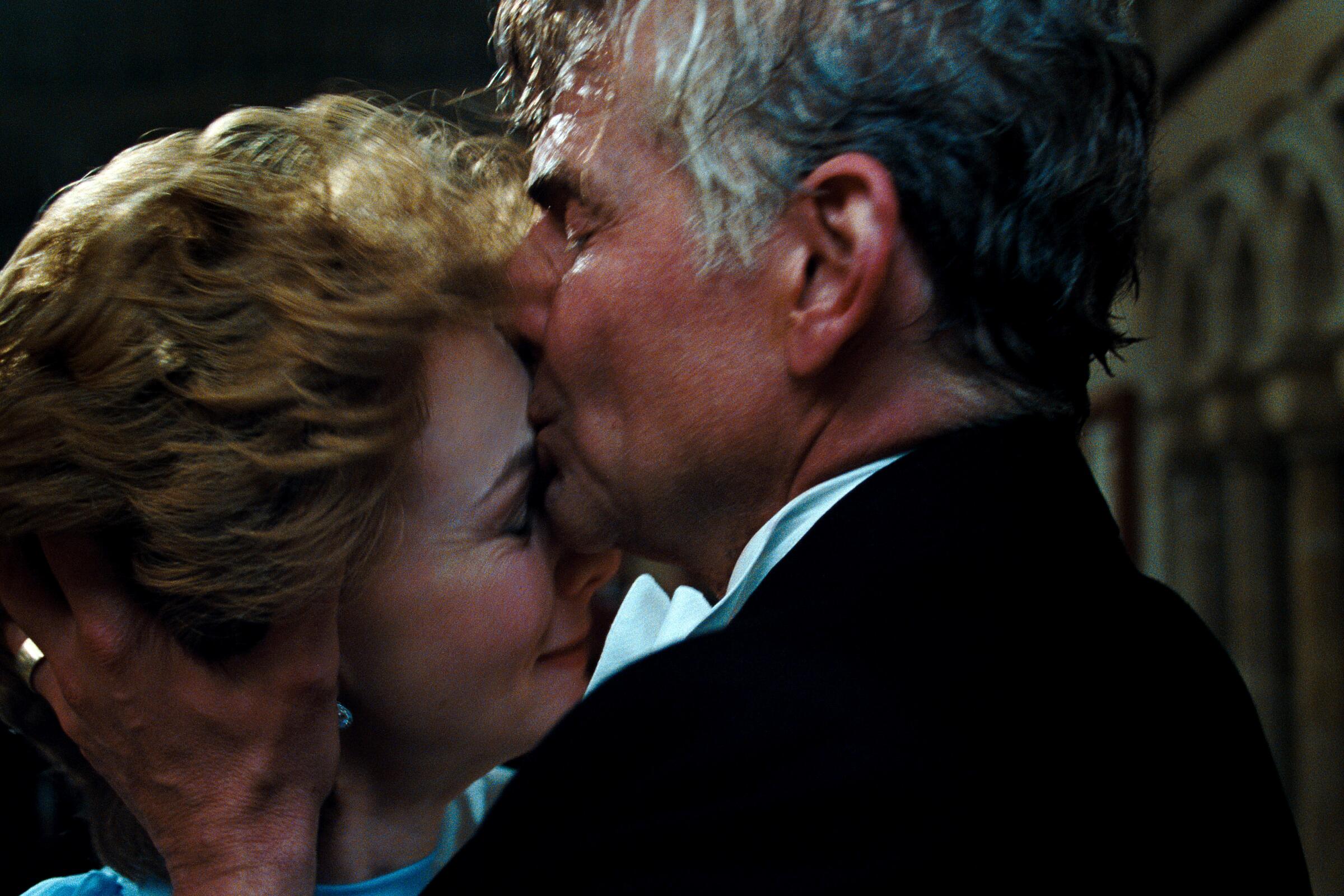 A man and woman embrace as he kisses her forehead in a scene from "Maestro."